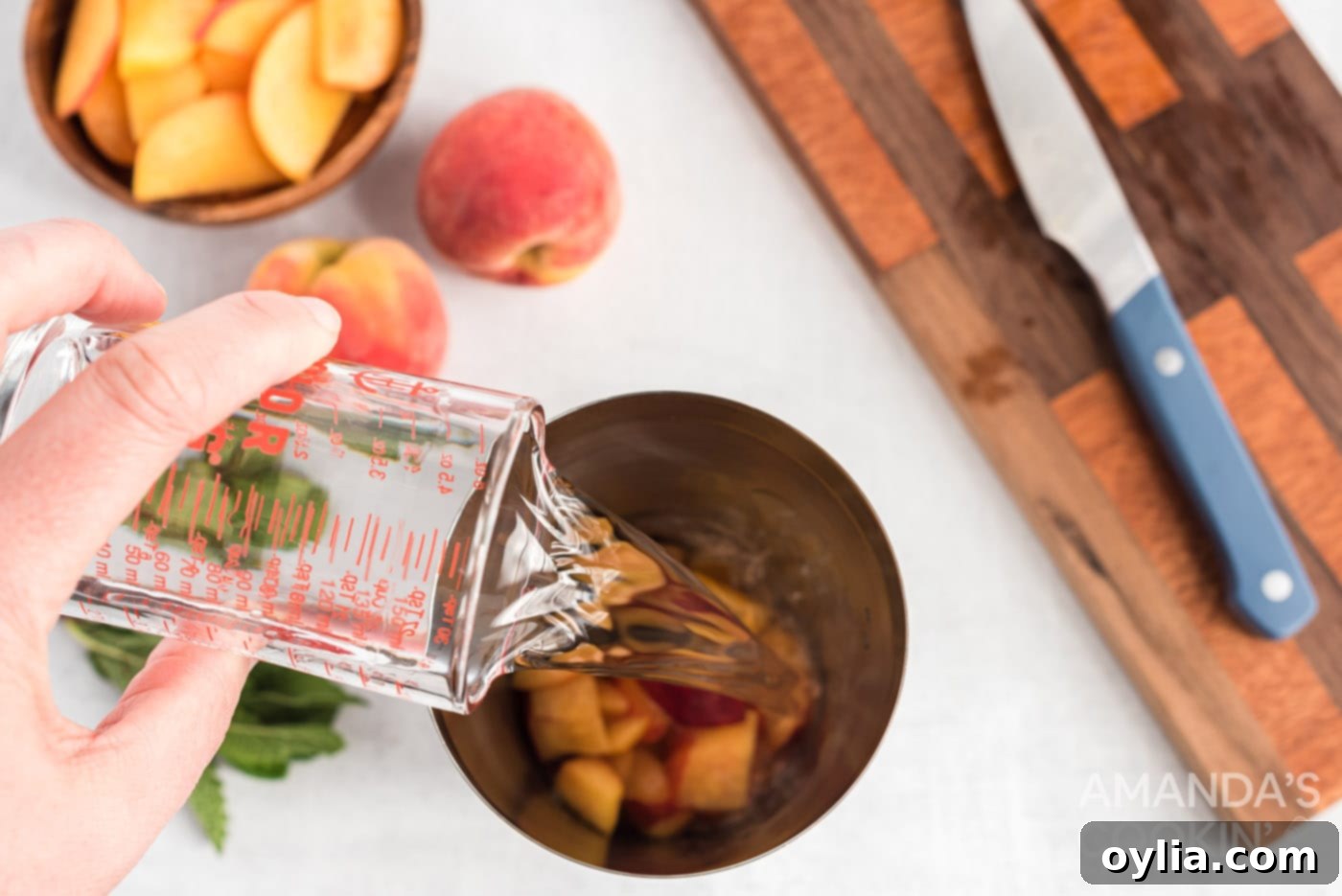Adding white rum to chopped peaches and sugar in a muddler, preparing for infusion.