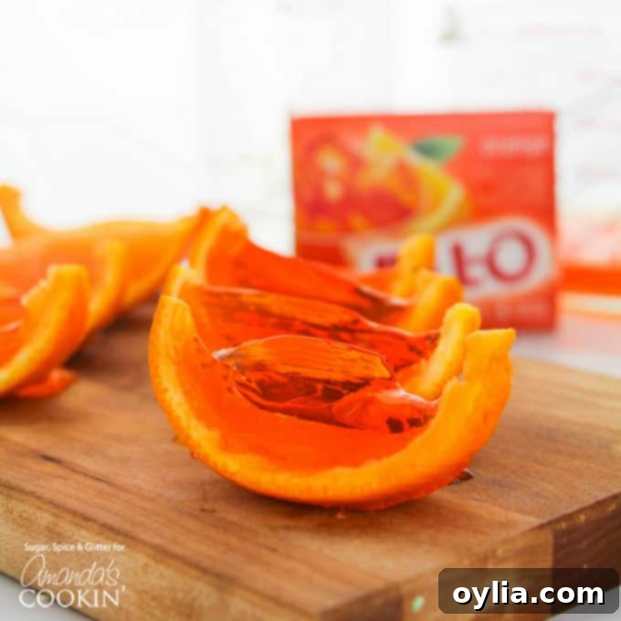 A top-down view of perfectly set orange Jell-O shots in their rinds, ready to be sliced, showcasing their vibrant color and smooth texture.