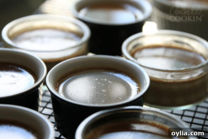 Transferring baked espresso creme brulee ramekins to a cooling rack.