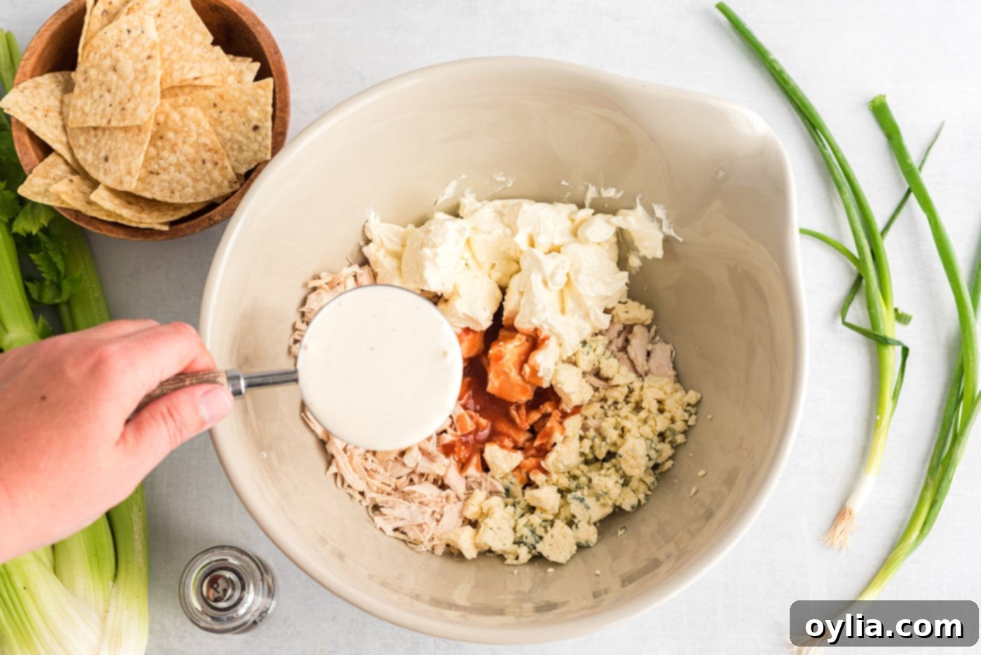 blue cheese, ranch, buffalo sauce, shredded chicken and cream cheese in a bowl