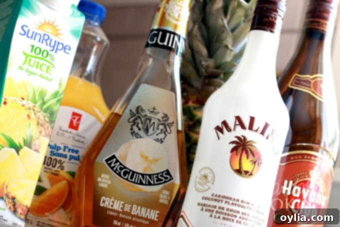 rum cruiser cocktail ingredients: bottles of rum, liqueur, and juices
