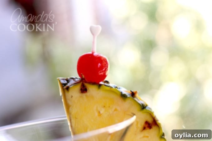 pineapple wedge and maraschino cherry on side of glass