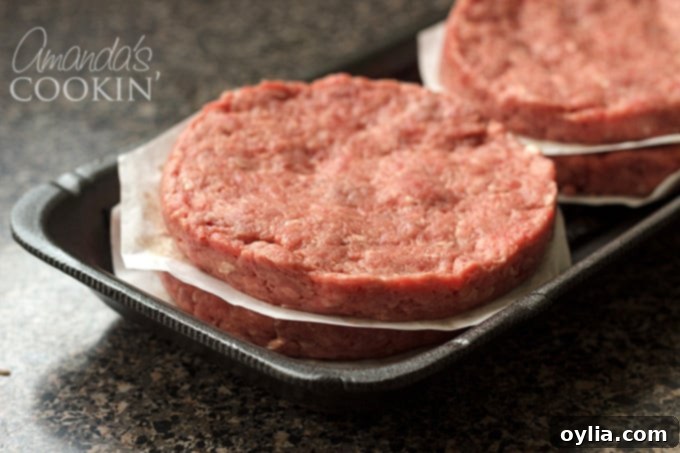 Four perfectly formed hamburger patties ready for the grill.