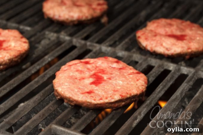 Hamburgers cooking on a hot grill, showing a good sear.