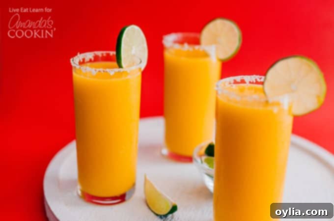 Mango Margarita Slush in glasses with a salted rim and lime garnish.