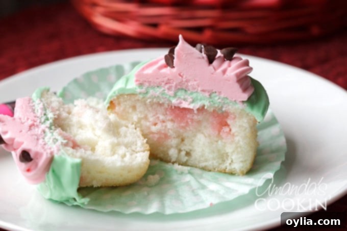 A watermelon poke cupcake cut in half, showcasing its layers