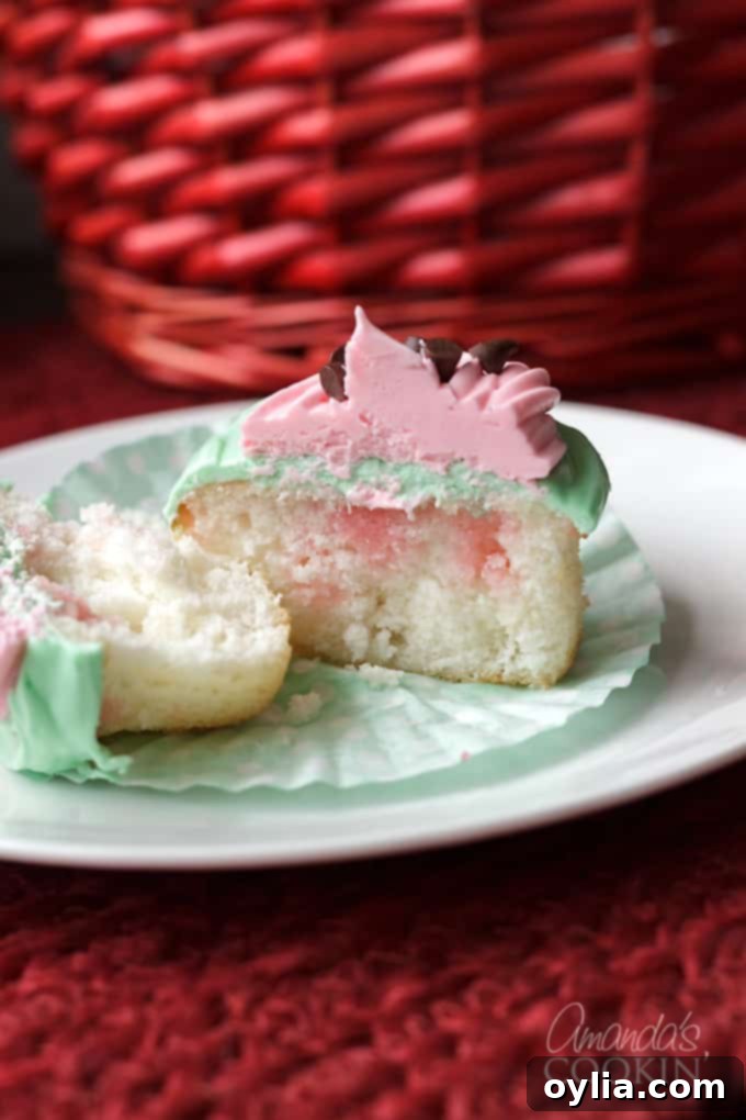 Watermelon poke cupcake cut in half revealing Jello infusion