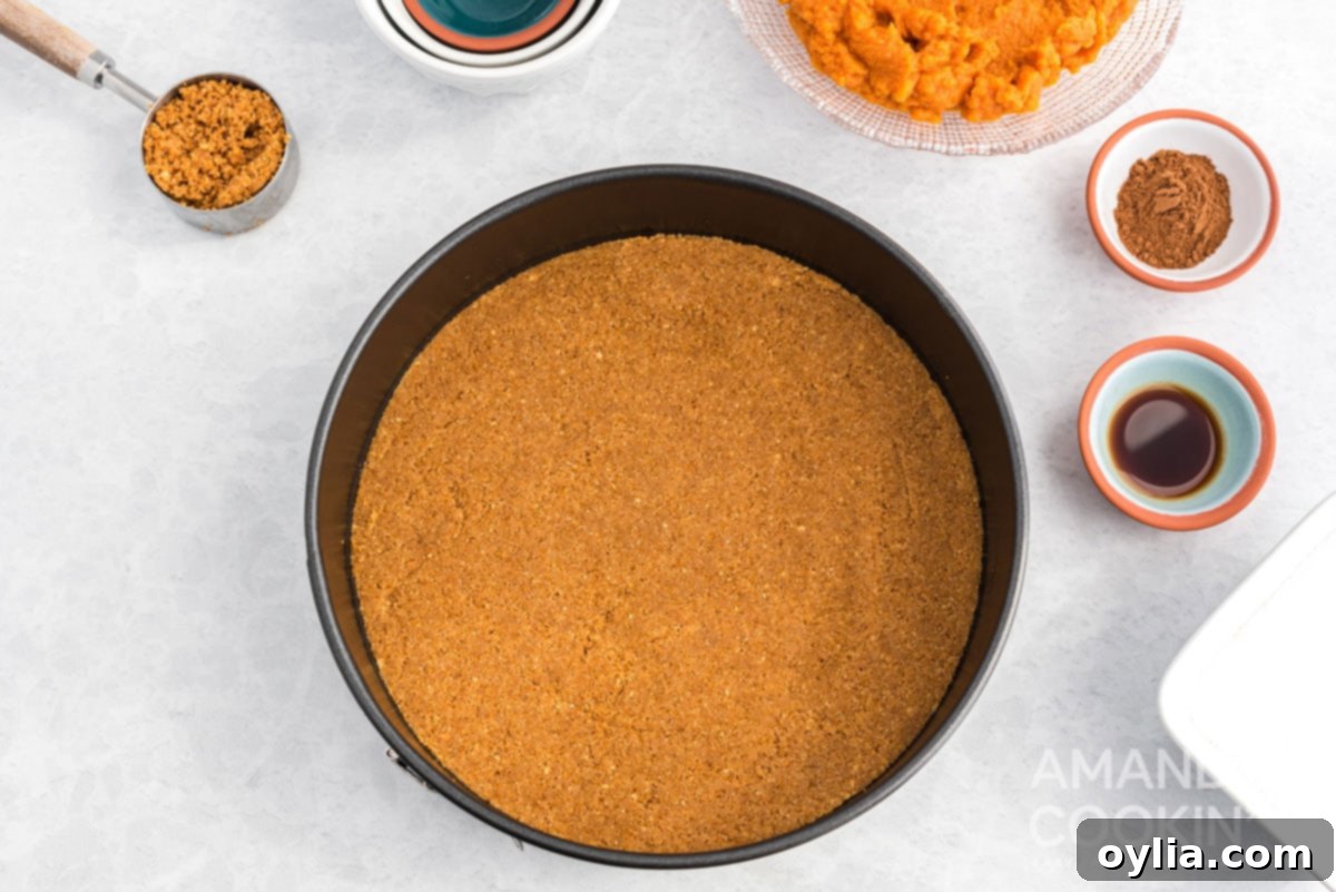 A perfectly pressed graham cracker crust chilling in a springform pan, ready for the cheesecake filling.