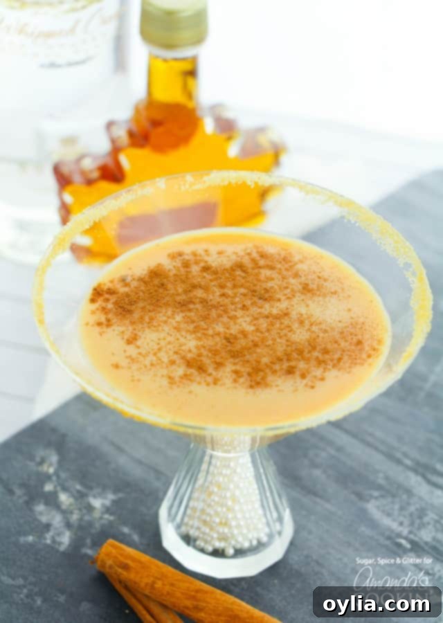 Pumpkin Pie martini with pumpkin spice and maple syrup garnish, ready for fall enjoyment.