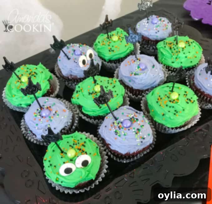 Chocolate Halloween cupcakes with purple and green frosting, sprinkles, and candy eyeballs, a fun and easy dessert.