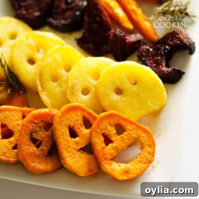 Roasted Halloween vegetables shaped like ghosts, pumpkins, and bats, including potatoes and carrots, a healthy and fun side dish.