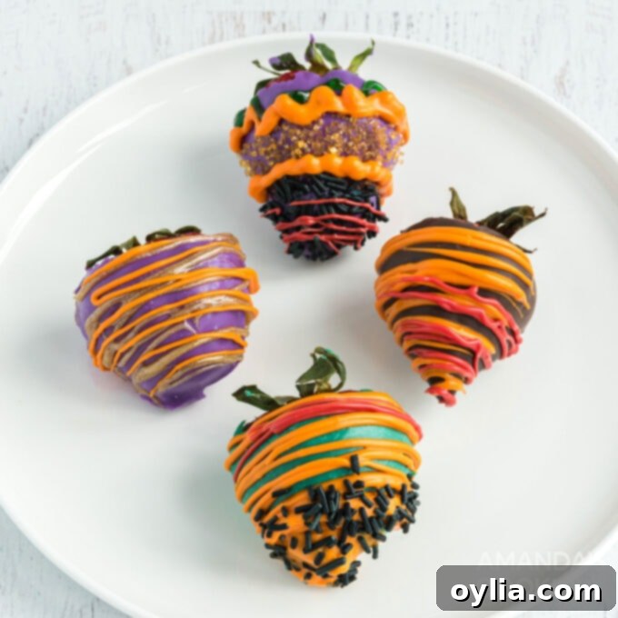 Halloween themed chocolate covered strawberries decorated with colorful candy melts and sprinkles, displayed on a plate.