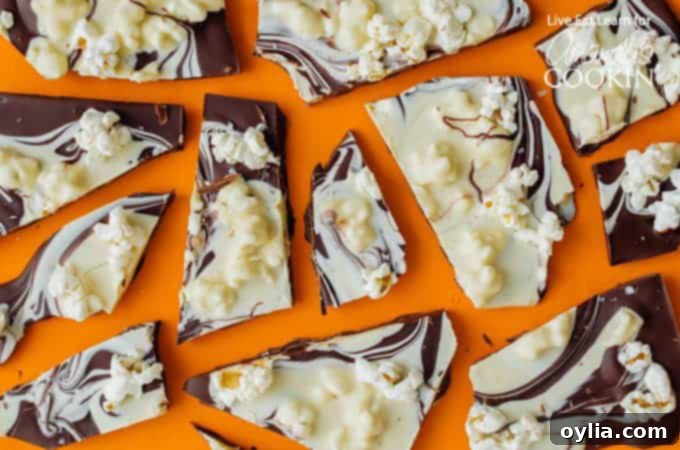 Crunchy popcorn chocolate bark spread out on parchment paper