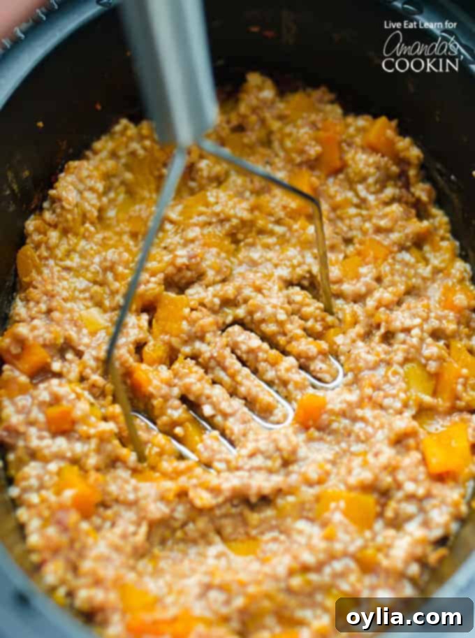 Mashing the butternut squash into creamy oatmeal in the crockpot