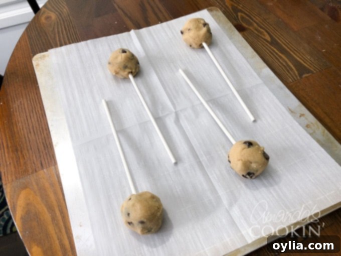 Lollipop sticks inserted into chocolate chip cookie dough balls