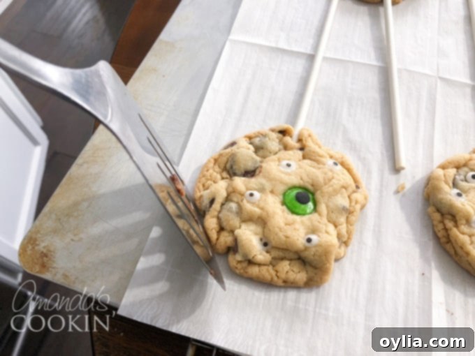 Rounding warm chocolate chip cookies with a spatula