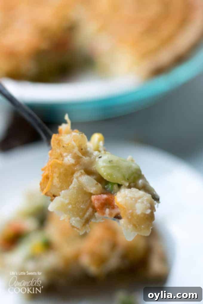 A forkful of creamy Chicken Pot Pie Tater Tot Casserole, showcasing the filling and crispy topping