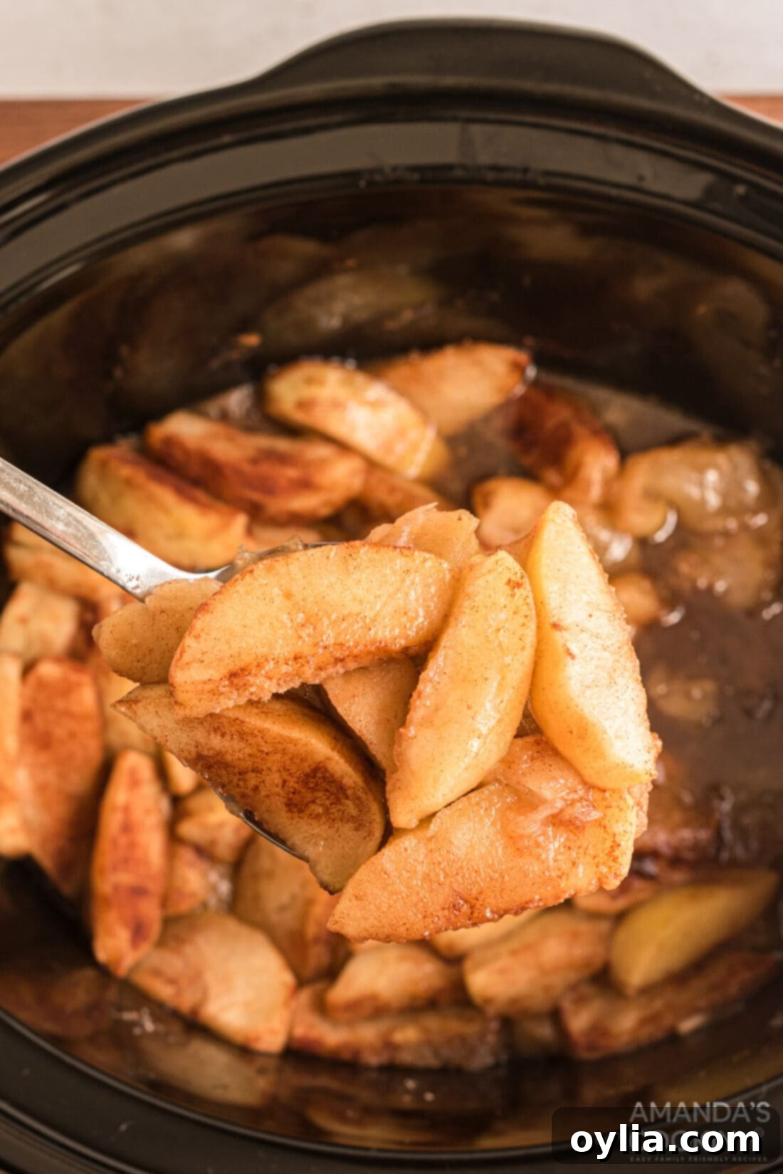 spooning out some Crockpot Cinnamon Apples