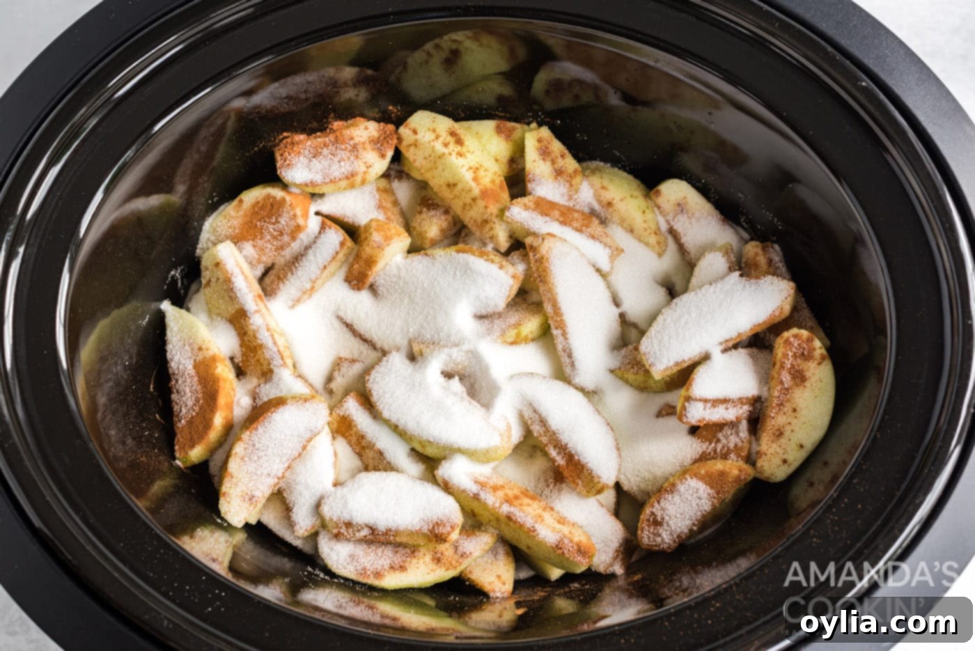 sugar and cinnamon on apple slices in crockpot