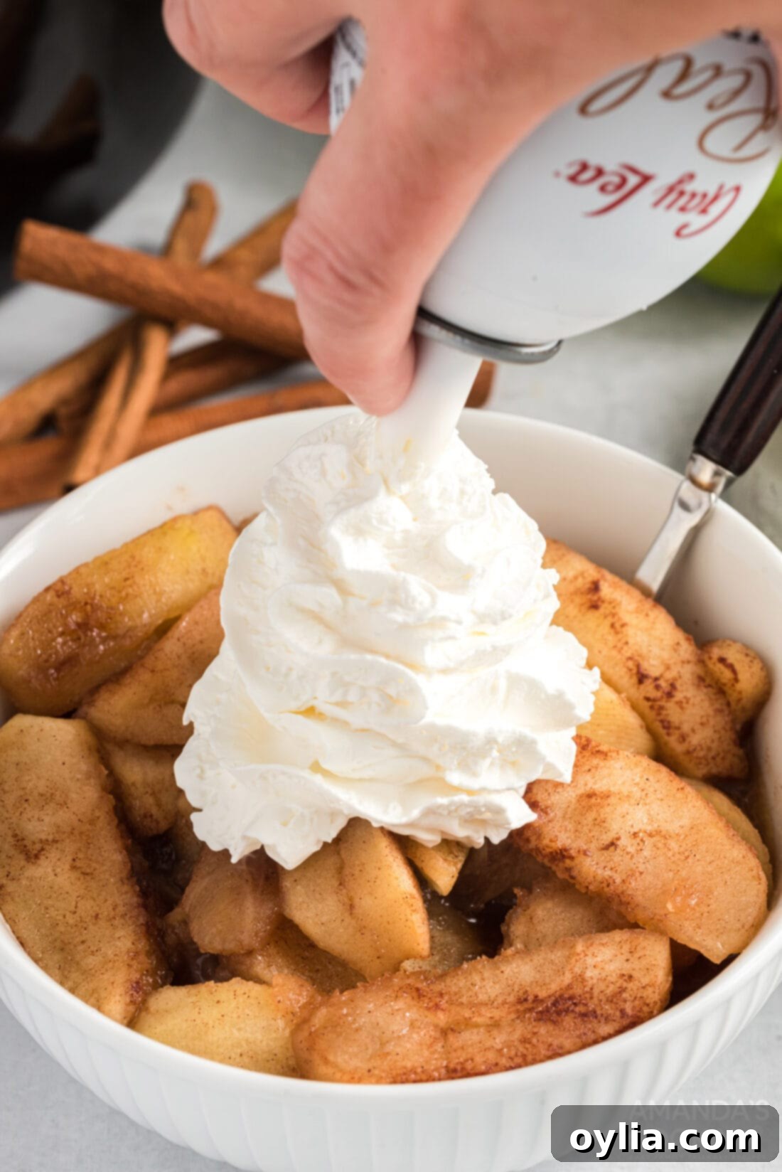adding whipped cream to Crockpot Cinnamon Apples