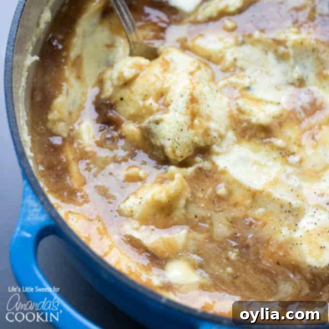 Creamy traditional mashed potatoes square photo Creamy homemade mashed potatoes with gravy in a blue pot, ready to serve