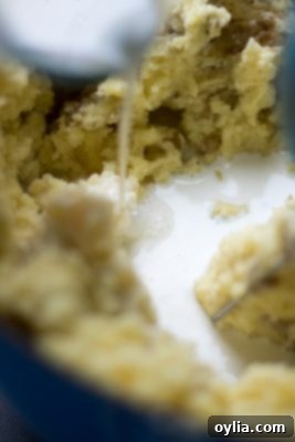 Half and half being poured into mashed potatoes