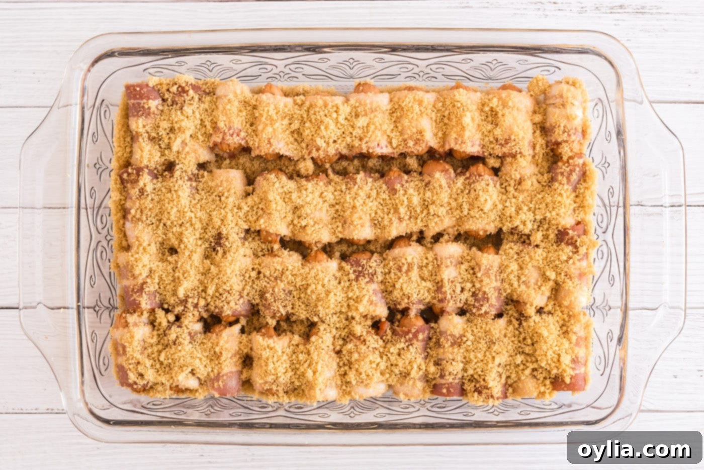 Bacon Wrapped Little Smokies topped with brown sugar, covered and ready for refrigeration
