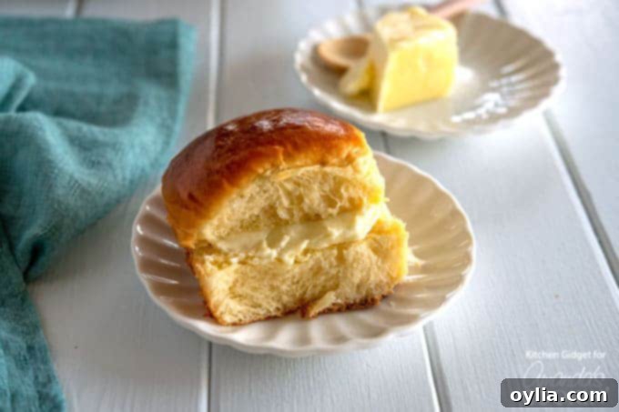 homemade hawaiian rolls on a plate with butter