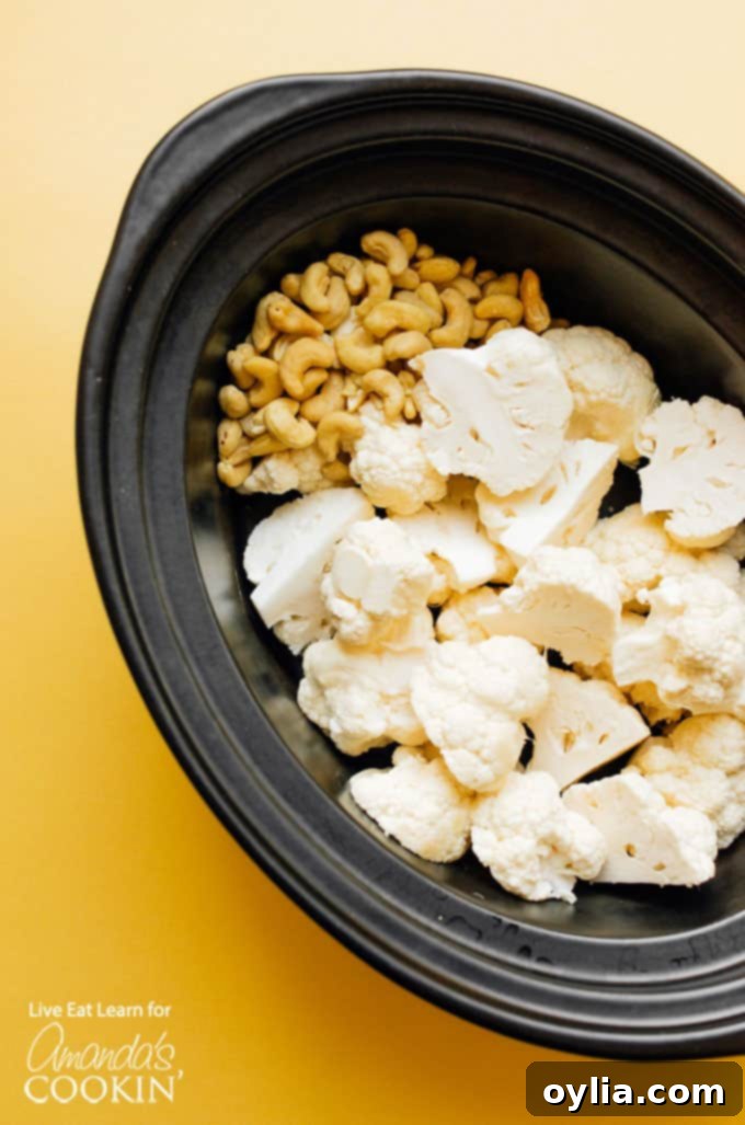 Ingredients for creamy cauliflower soup in a slow cooker pot