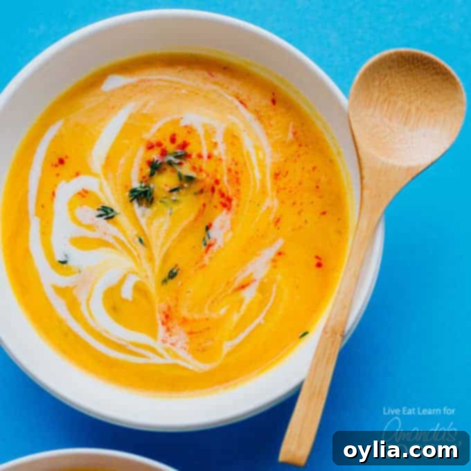 Creamy cauliflower soup in a bowl with a wooden spoon