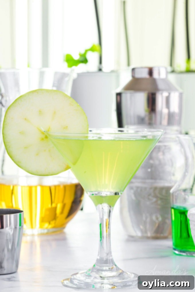 appletini in a martini glass with ingredients in the background