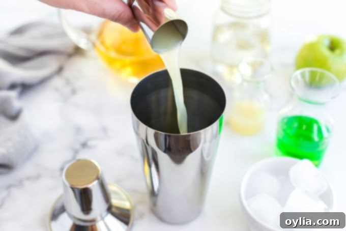 pouring lemon juice into a cocktail shaker