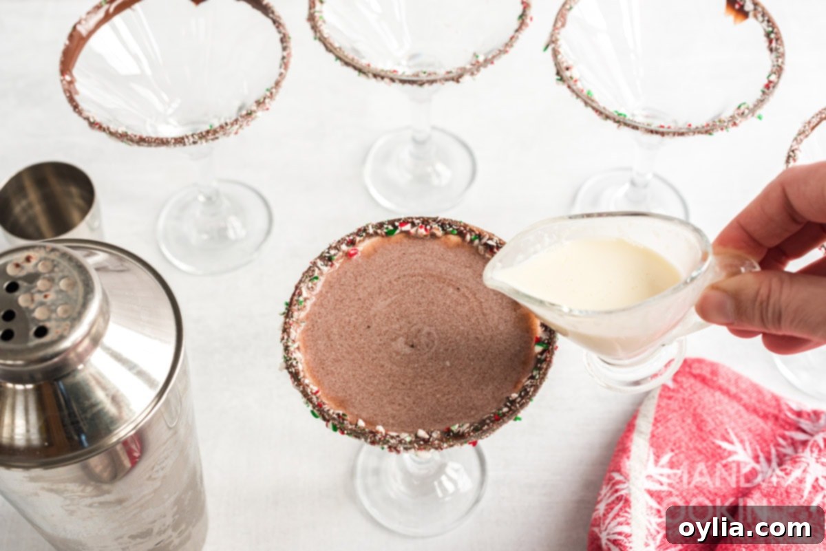 Adding a decorative swirl of cream to the top of the chocolate peppermint martini.
