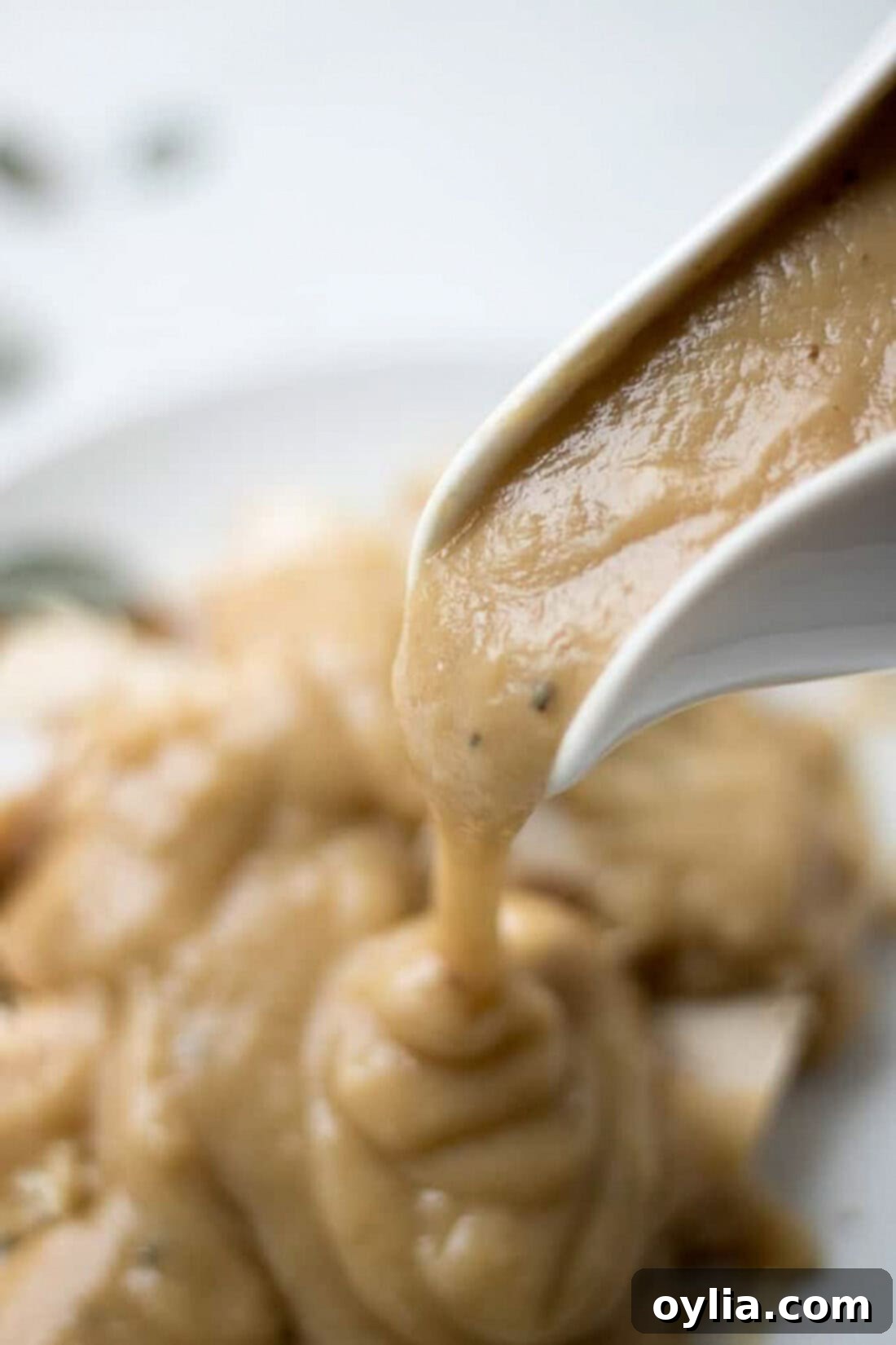 The Ultimate Homemade Turkey Gravy 13 Rich Homemade Turkey Gravy pouring smoothly from a gravy boat into a serving dish