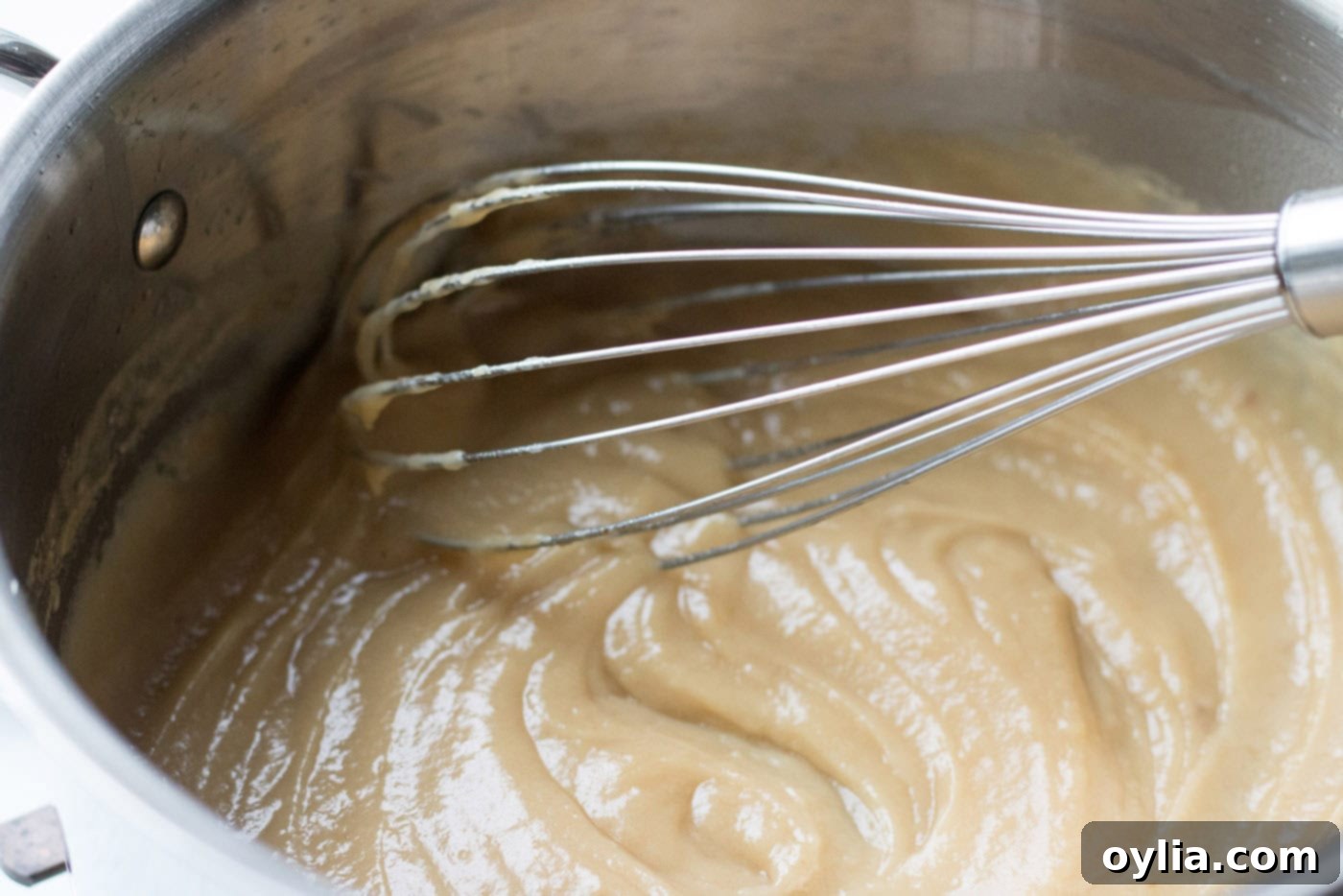 Whisk blending melted fat and all-purpose flour in a saucepan to form a roux