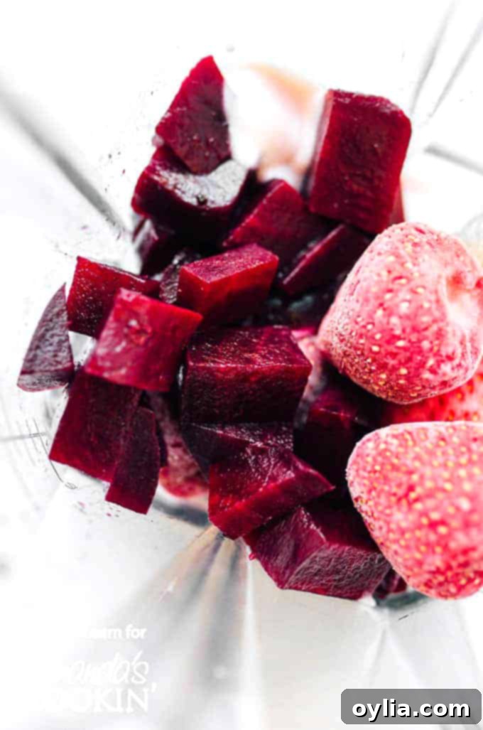 Diced red beets and fresh strawberries ready to be added to a blender for a healthy smoothie.