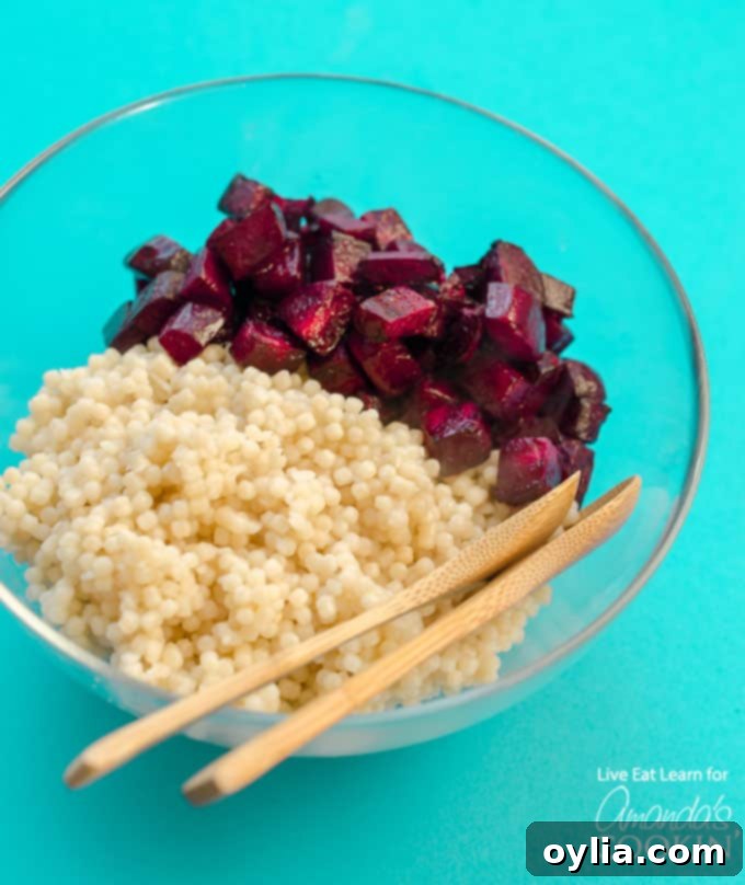 Cooked pearl couscous and roasted beets mixed in a bowl