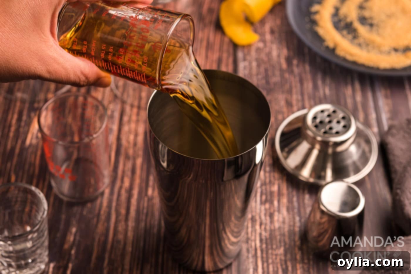 pouring cognac into cocktail shaker