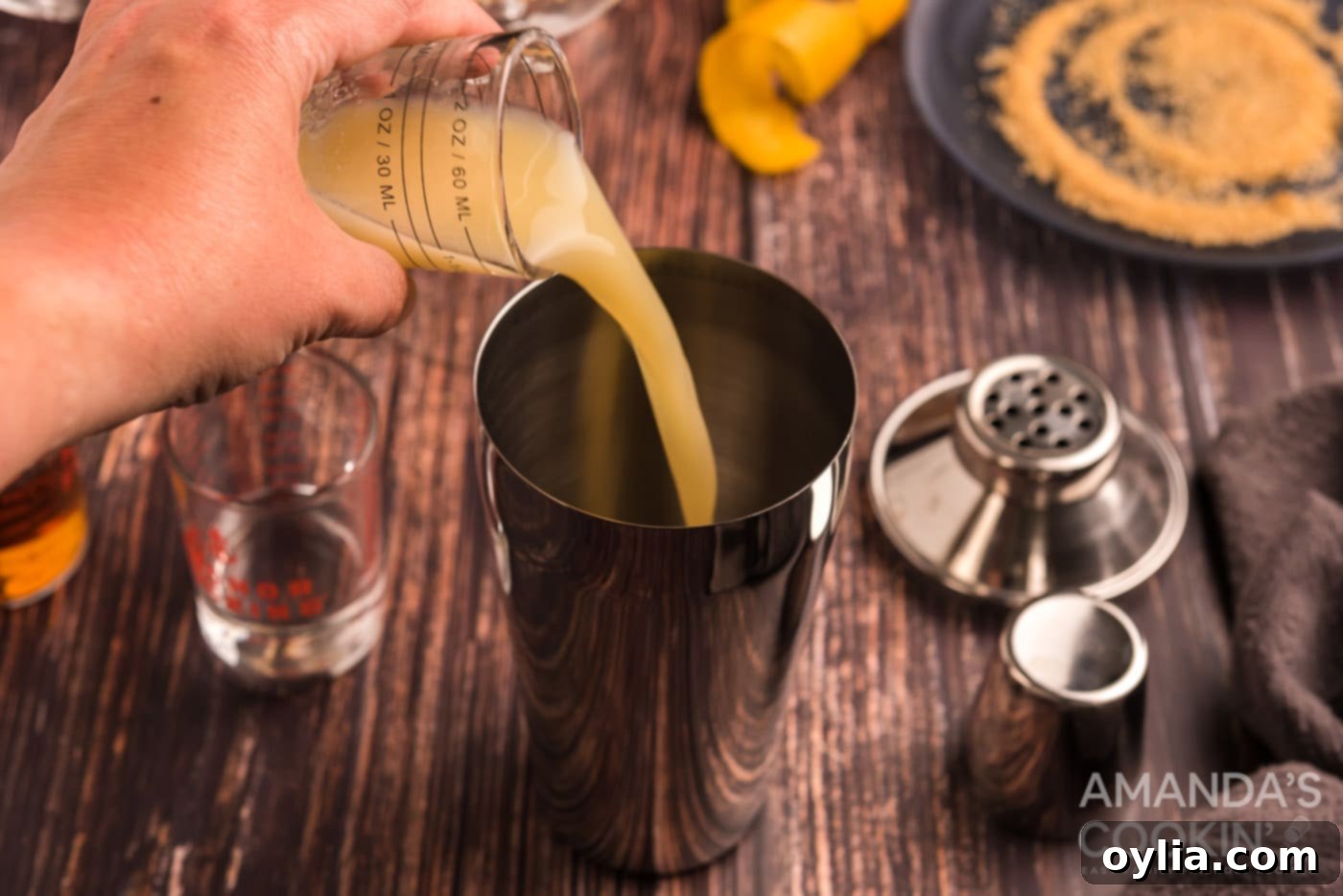 pouring lemon juice into cocktail shaker