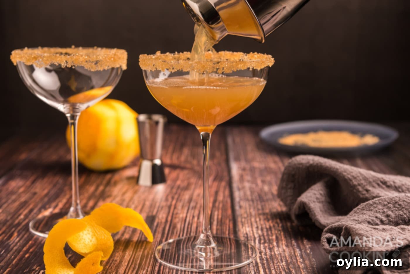 pouring sidecar cocktail into a glass