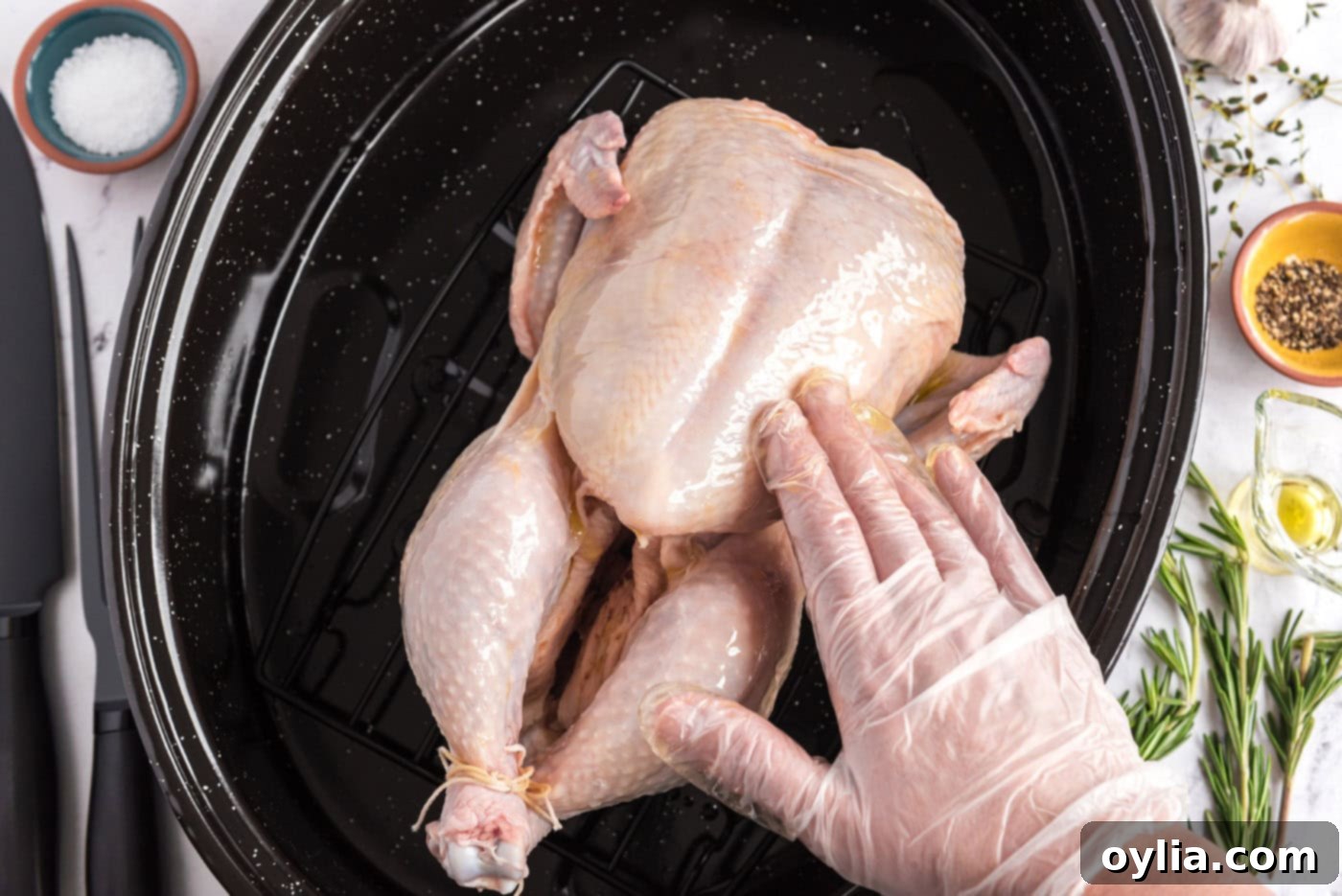 rubbing chicken with olive oil in a roasting pan