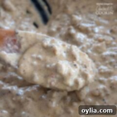 close up of sausage gravy in pan with wooden spoon