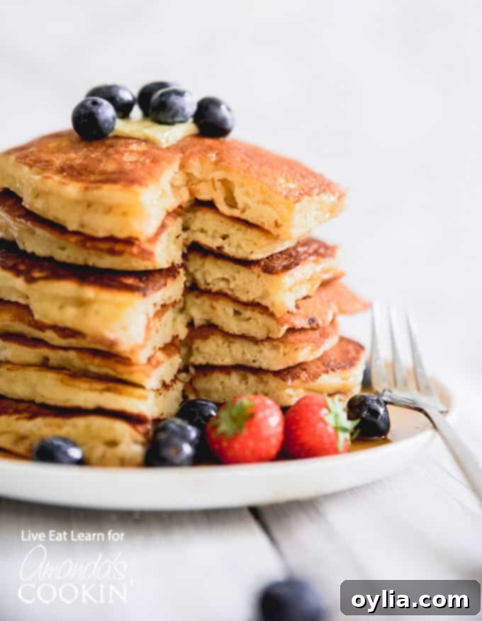 A stack of perfectly golden-brown, fluffy homemade buttermilk pancakes, ready to be served