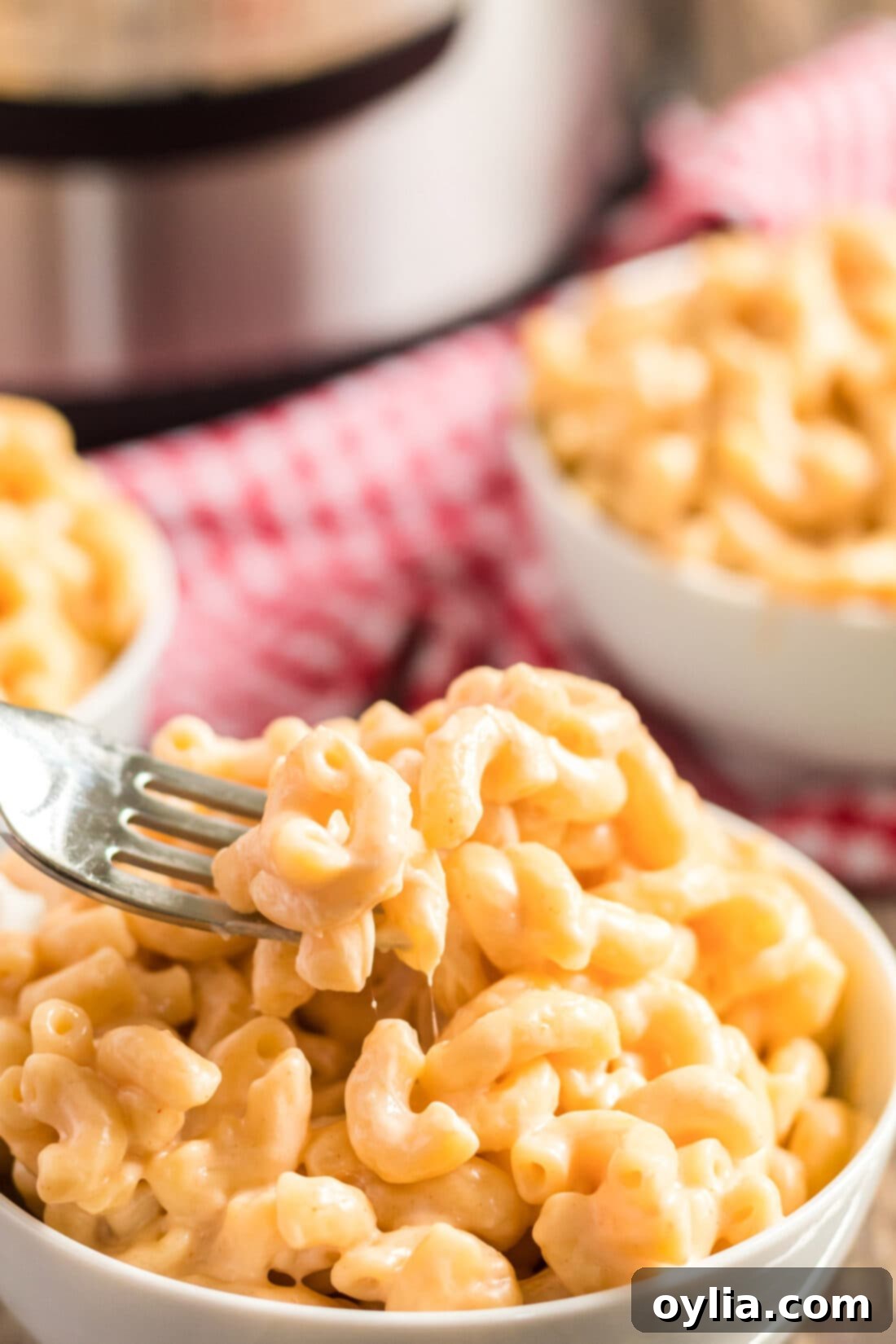 Fork digging into a bowl of homemade Instant Pot Mac and Cheese