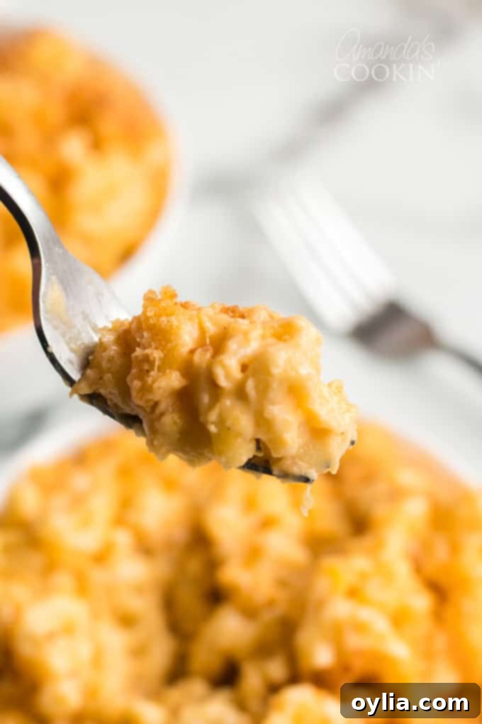 Close-up of baked macaroni and cheese on a fork, showcasing its creamy texture and rich cheese