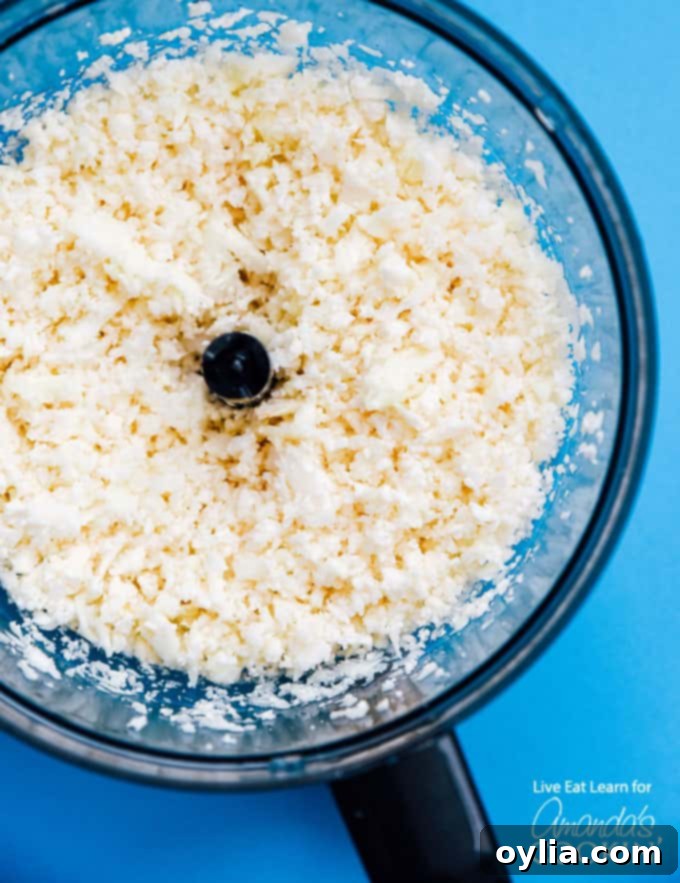 Cauliflower florets being blitzed in a food processor to make cauliflower rice