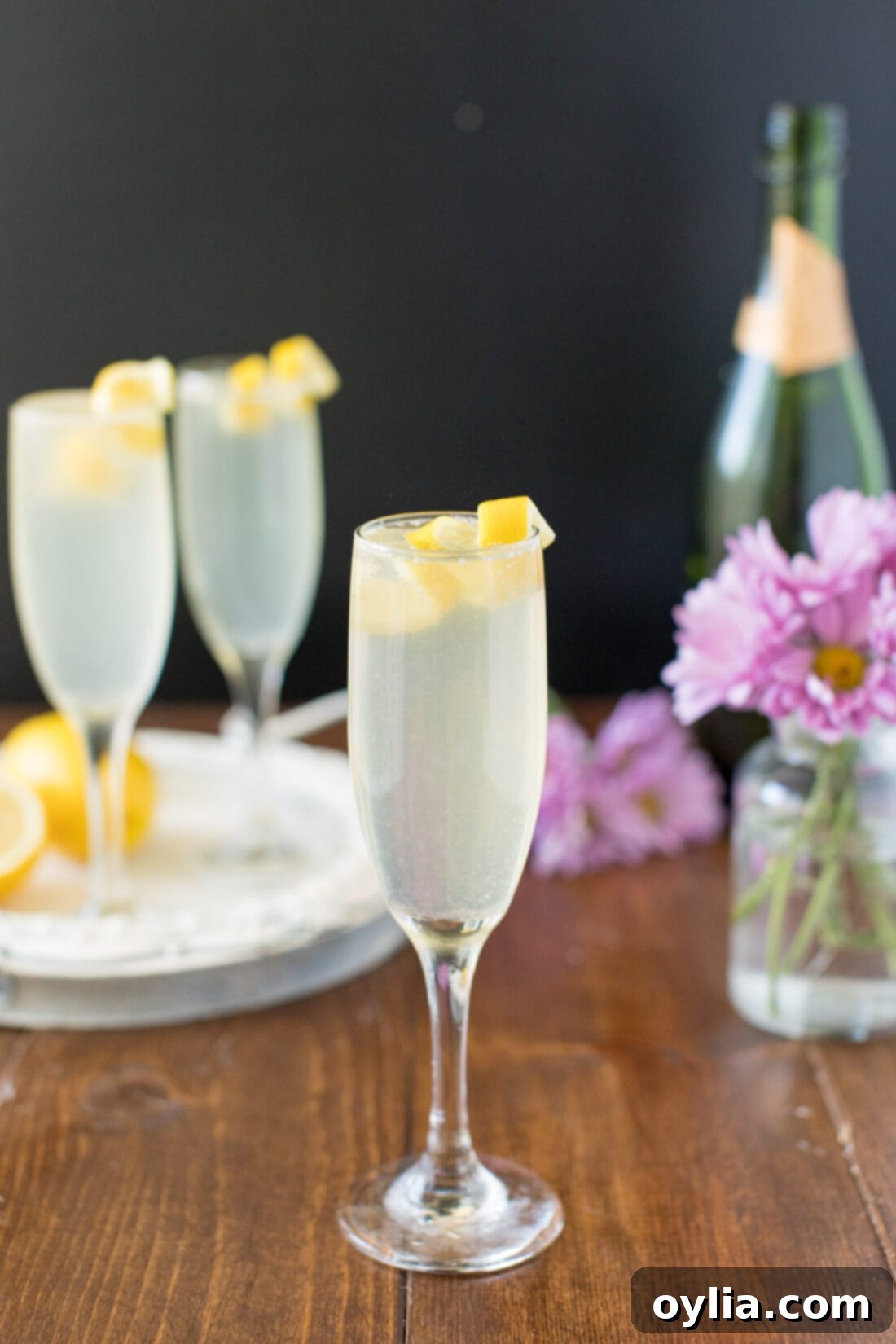 Classic French 75 Cocktail for Celebrations A French 75 cocktail garnished with a vibrant lemon twist, sparkling in a champagne flute