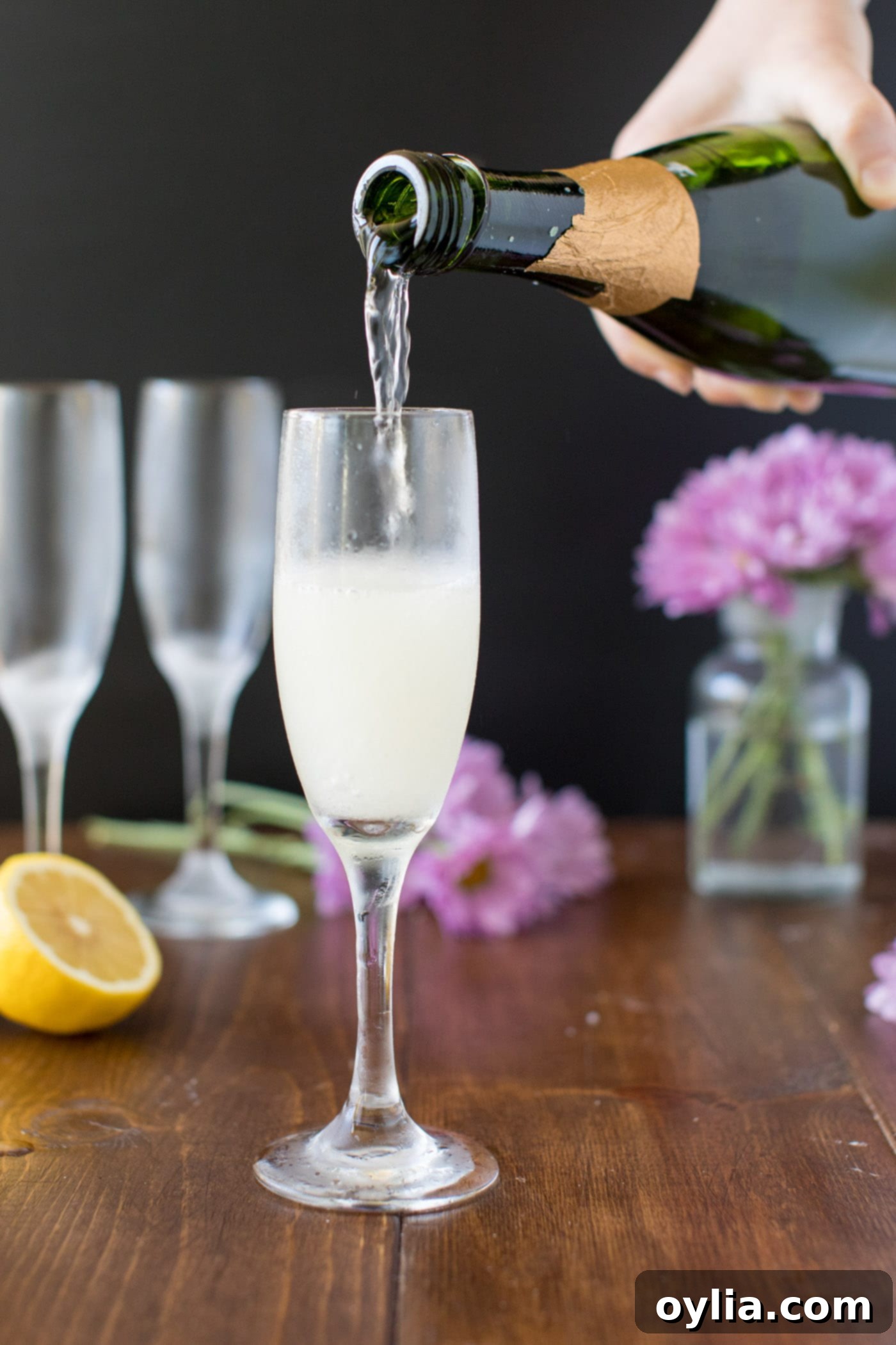 Topping a French 75 cocktail with Brut champagne in a flute