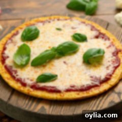 Pizza made with a Cauliflower Pizza Crust on a wooden board, showcasing a delicious low-carb meal.