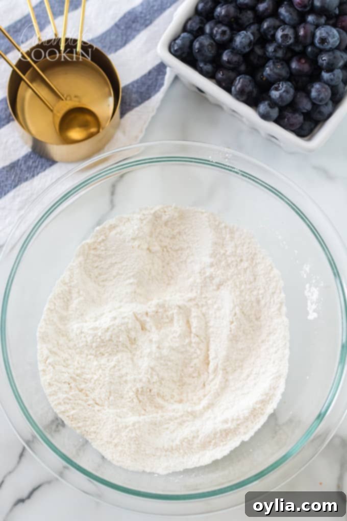 A bowl with dry ingredients for blueberry muffins: flour, sugar, salt, baking powder